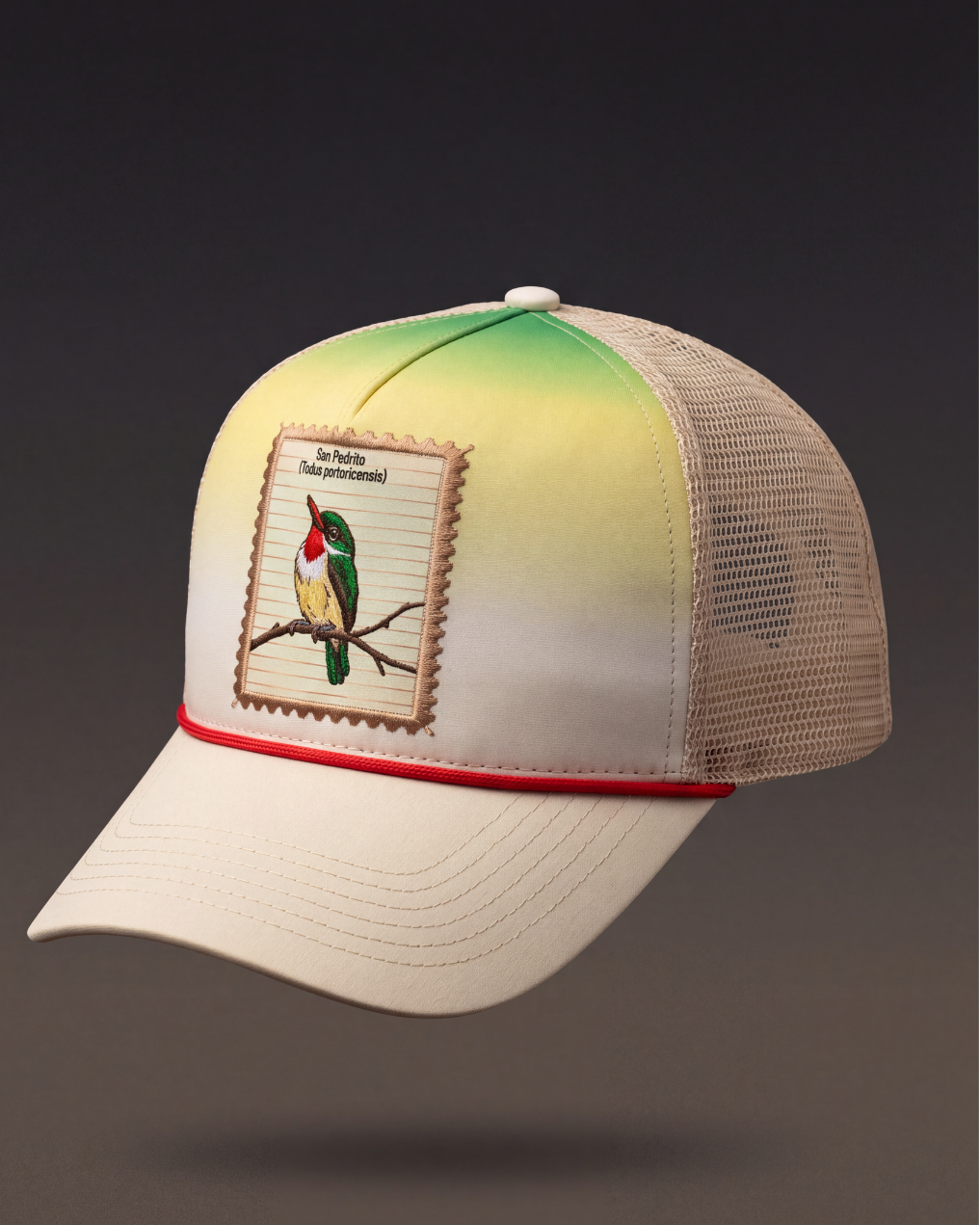 A trucker-style baseball cap with a cream-colored front panel and brim, a green-to-yellow gradient on the back panels, a red piping accent along the edge of the brim, and a square embroidered patch depicting a bird on a branch. The cap is shown floating against a dark gray gradient background.