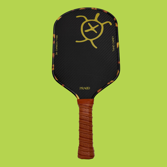 Taíno Carey Paddle with 3K T700 carbon fiber face, 14mm honeycomb core, elongated brown leather handle, and tortoiseshell edge design for responsive control and power.