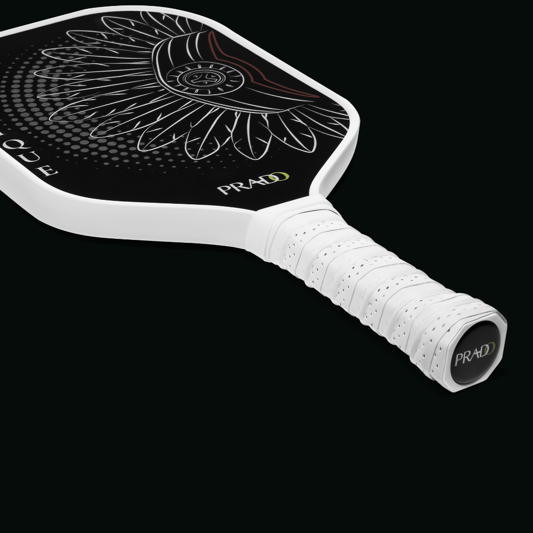 Close-up of the Cacique Pickleball Paddle surface, highlighting the white Taíno chief design and the textured raw carbon face.