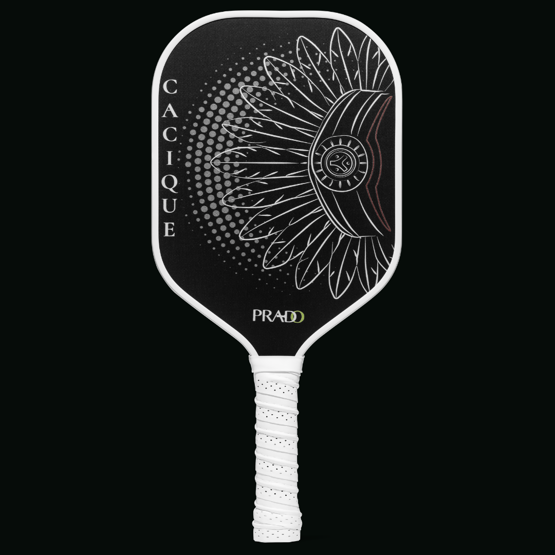Front view of the Prado Activewear Cacique Pickleball Paddle, featuring a black Raw Carbon T700 face and a white Taíno-inspired graphic.