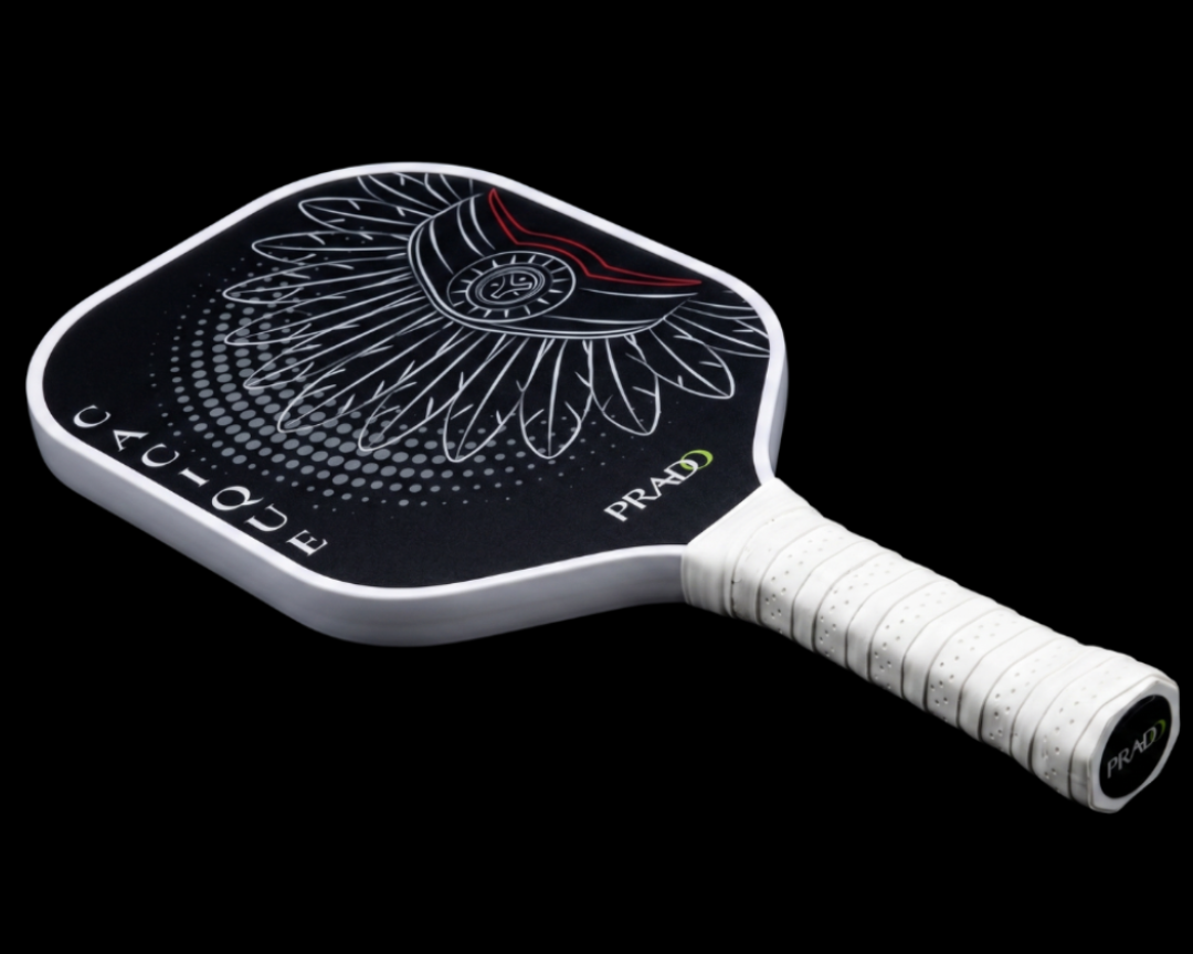 Cacique Pickleball paddle with a black and white design on a black background